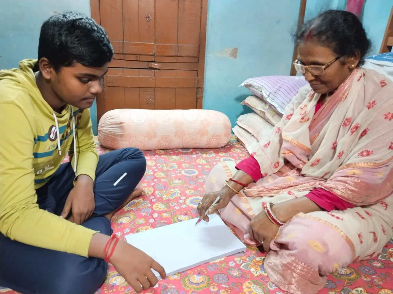 a DIKSHA student volunteer teaching an adult at home